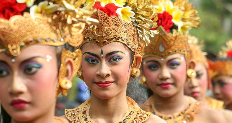 Women dressed in traditional Balinese costumes with floral headdresses.