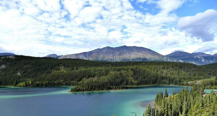 A tranquil lake with a mountain range in the background.