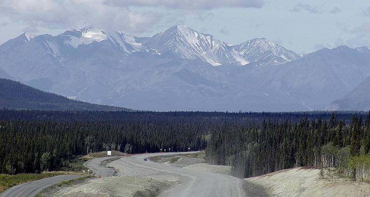 A remote highway leading towards a mountain range.