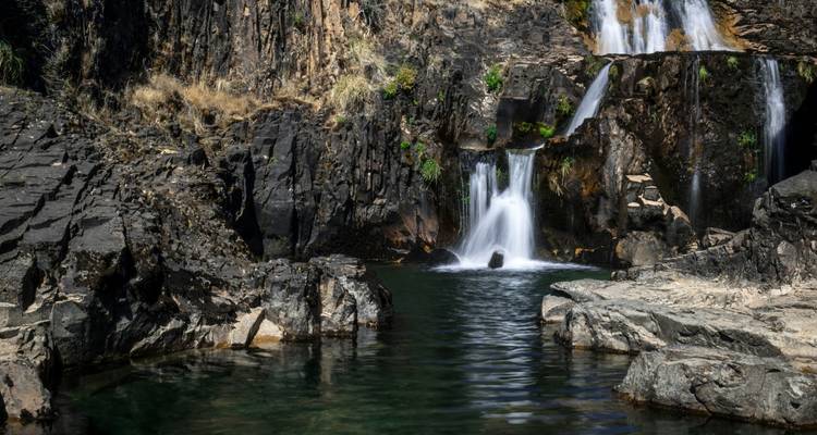 Pequeña cascada que desemboca en un estanque rocoso.