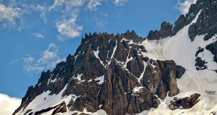 Picos nevados con imponentes paredes rocosas escarpadas.