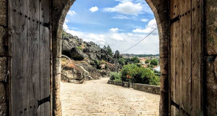 Blick durch einen steinernen Torbogen auf einen ländlichen Pfad.