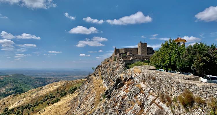 Château sur une colline rocheuse avec vue sur un vaste paysage.