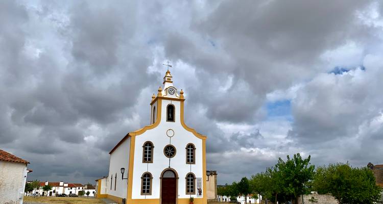 Église blanche avec un ciel nuageux.