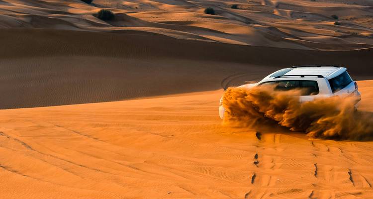 Véhicule 4x4 roulant sur les dunes de sable dans le désert.