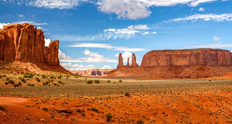 Iconic rock formations under a clear blue sky in a desert landscape.