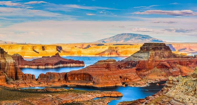 A stunning landscape of rocky formations and a lake under a clear blue sky.