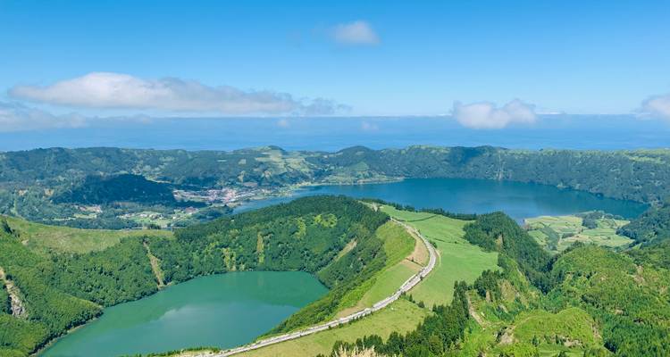 Vue aérienne d'un lac partiellement encerclé par une forêt et des champs.