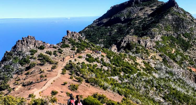 Hike on a mountain trail with expansive views of the landscape below.