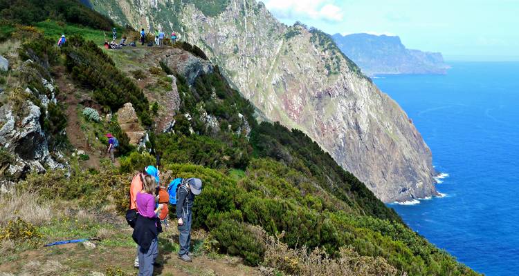 Hikers on a cliff with stunning ocean views.