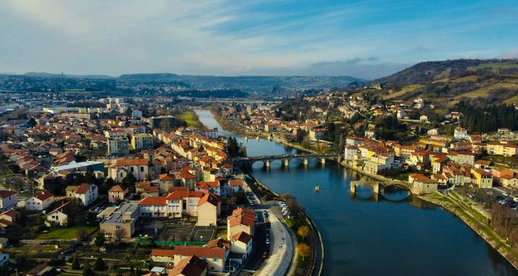 Aerial view of a city with a river, hills, and bridges.