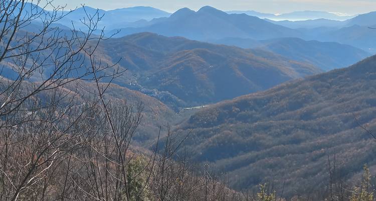 Het schilderachtige uitzicht op glooiende heuvels met verre dorpen onder een blauwe hemel.