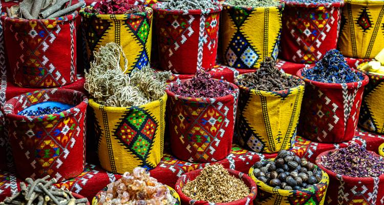 Kleurrijke kruidenmanden tentoongesteld op een markt.