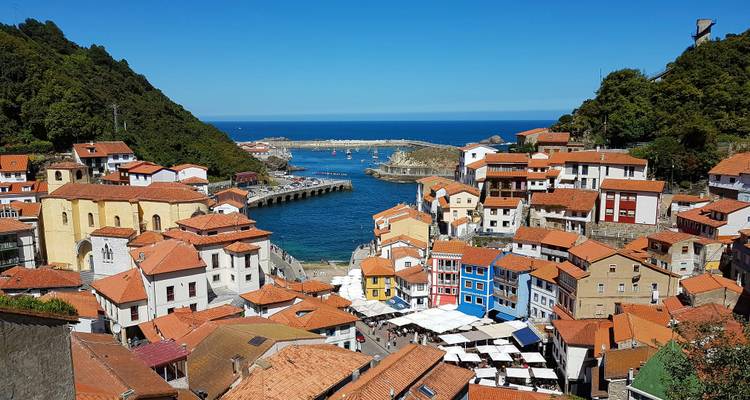 Ville portuaire avec des maisons colorées et une marina animée.