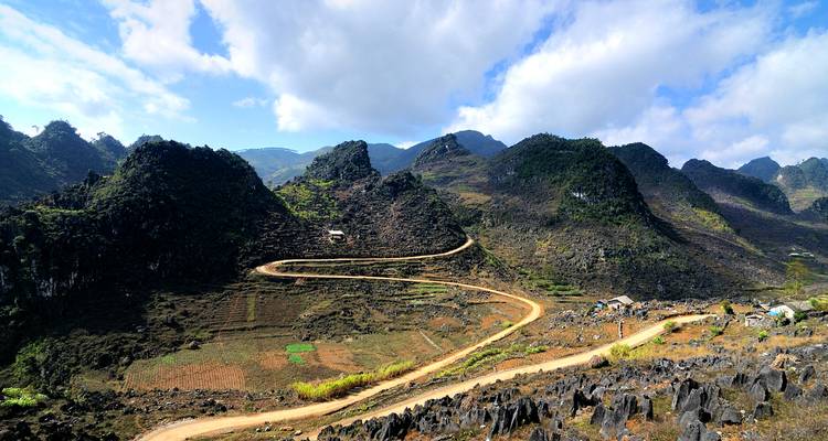 Curved dirt road winding through rocky hills.