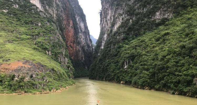 Steile kalkstenen rotswanden omlijsten een kronkelende groene rivier die door een spectaculaire kloof snijdt.