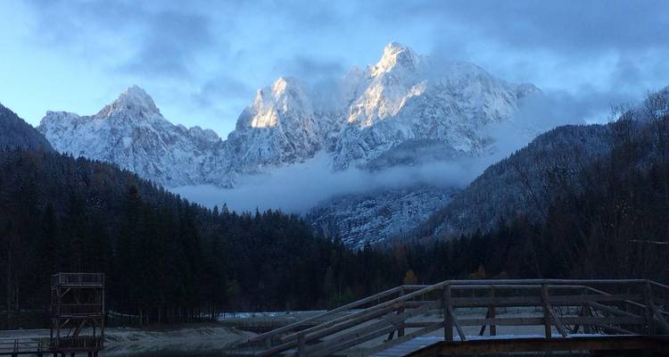 Sommets de montagne enneigés avec une plateforme d'observation en bois.