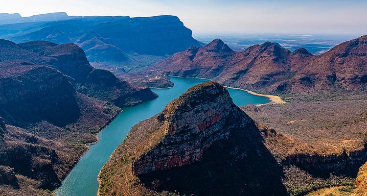 Vue à couper le souffle d'un canyon avec une rivière sinueuse dans un paysage montagneux.