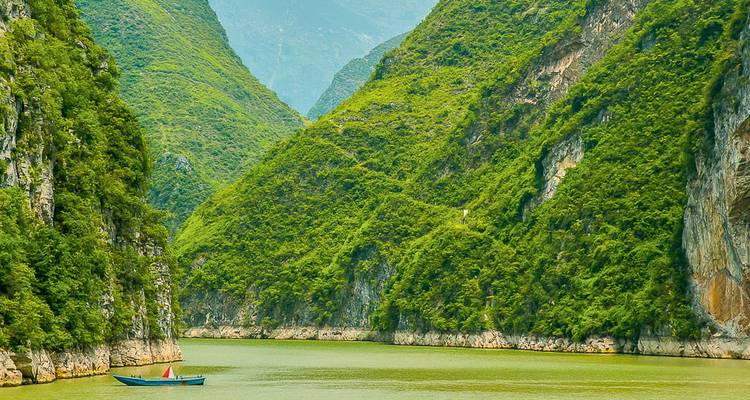 A tranquil river flowing between lush green hills.