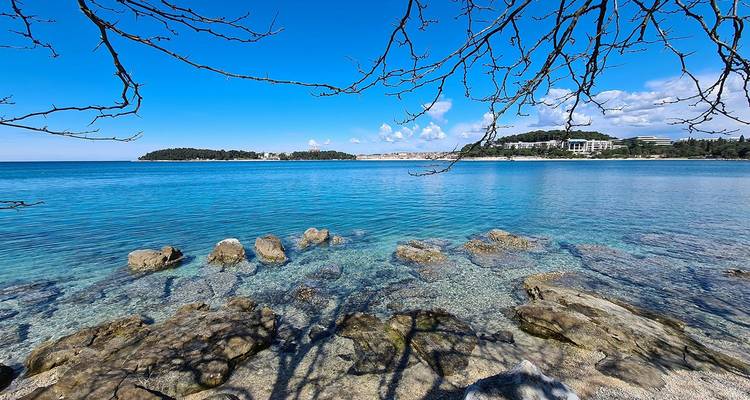 Mar turquesa cristalino, costa rocosa y cielo azul brillante de Istria.