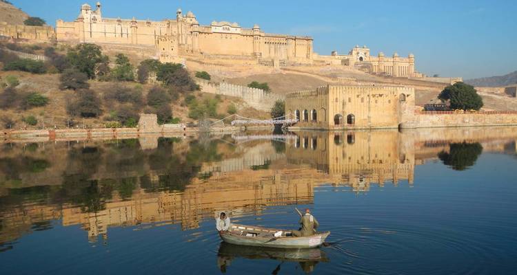 Un fuerte histórico reflejado en aguas tranquilas con un pequeño bote.