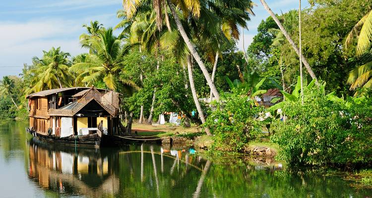 Péniche sur une rivière sereine entourée d'une végétation luxuriante.