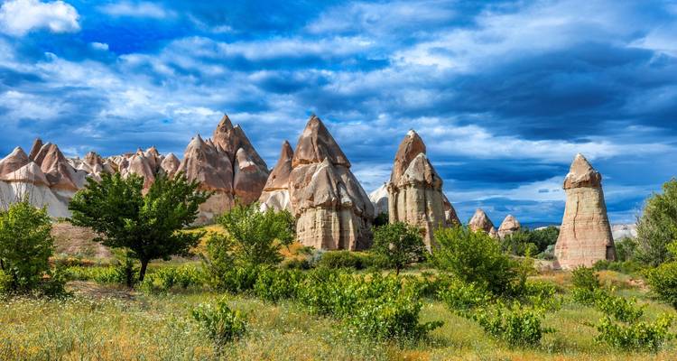 Dramáticas agujas de roca puntiaguda en Capadocia contra un cielo azul sombrío