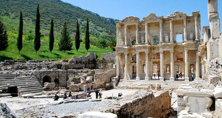 Ruinen der Antiken Bibliothek von Celsus mit Besuchern, die zwischen Säulen in heller Sonneneinstrahlung spazieren
