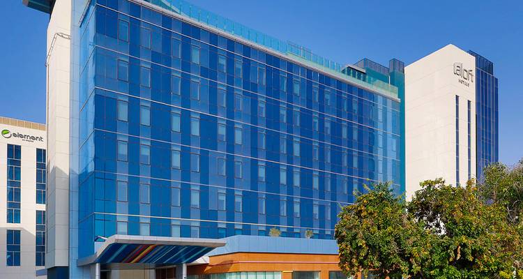 Vue extérieure d'un bâtiment d'hôtel moderne avec des fenêtres en verre bleu.