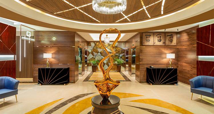 Hall d'hôtel opulent avec une sculpture artistique centrale.