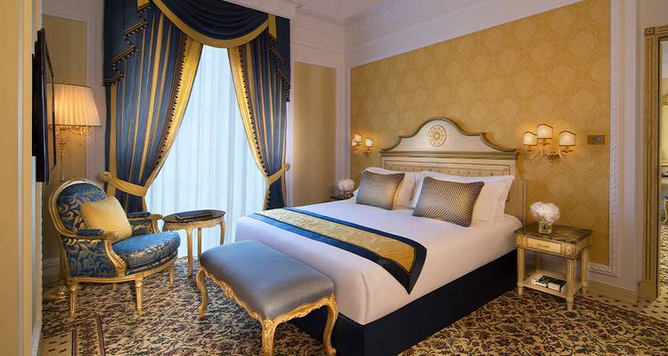 Luxurious hotel room with gold and blue decor.