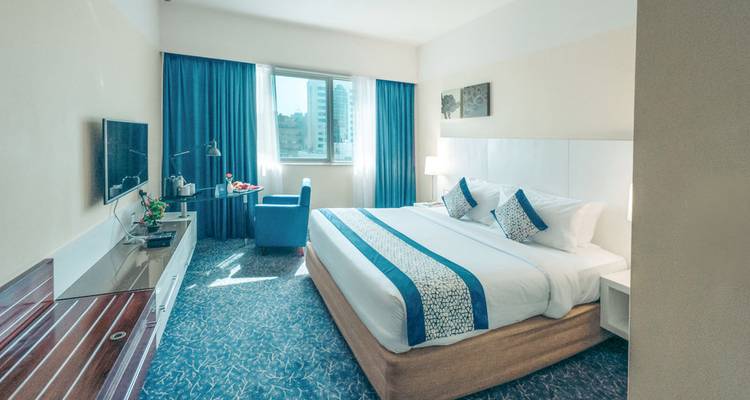 Basic hotel room with blue color scheme.