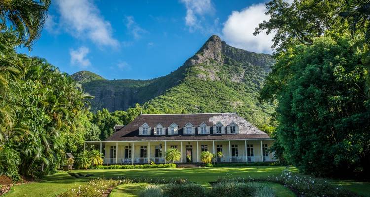 Charmante maison de maître entourée de pelouses verdoyantes et de montagnes.