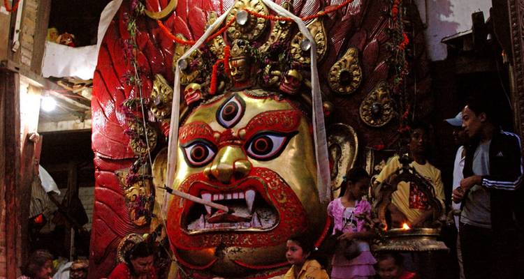 Große Göttinnenmaske umgeben von Menschen während eines Festivals