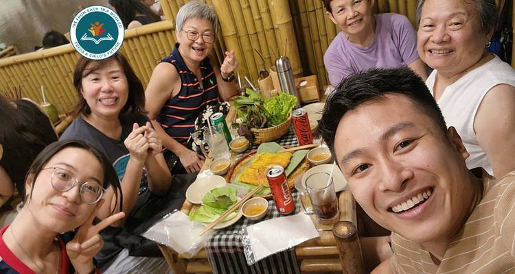Un grupo de personas disfrutando de una comida juntas en el interior.