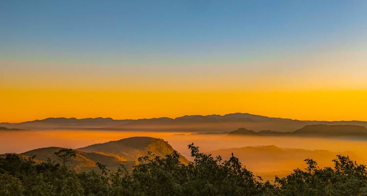 Lever de soleil coloré sur un paysage couvert de brume.