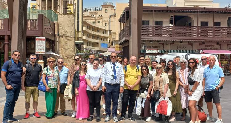 A large group of tourists standing in a market area.