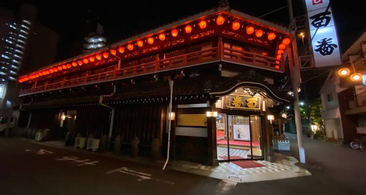 Traditional Japanese building with red lanterns at night.