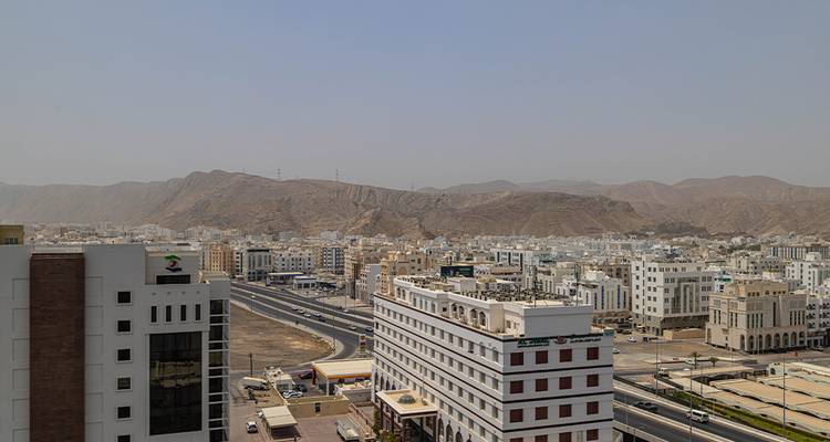 Vue de la ville avec des bâtiments et des montagnes en arrière-plan.