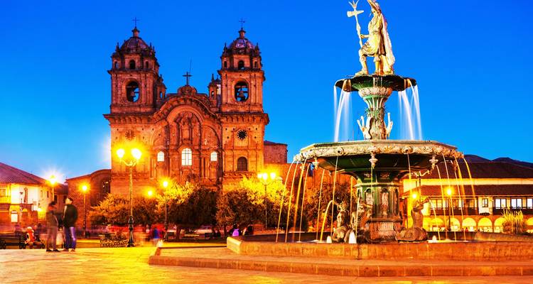 Scène du soir dans une cathédrale avec fontaine à Cusco avec éclairage chaleureux.