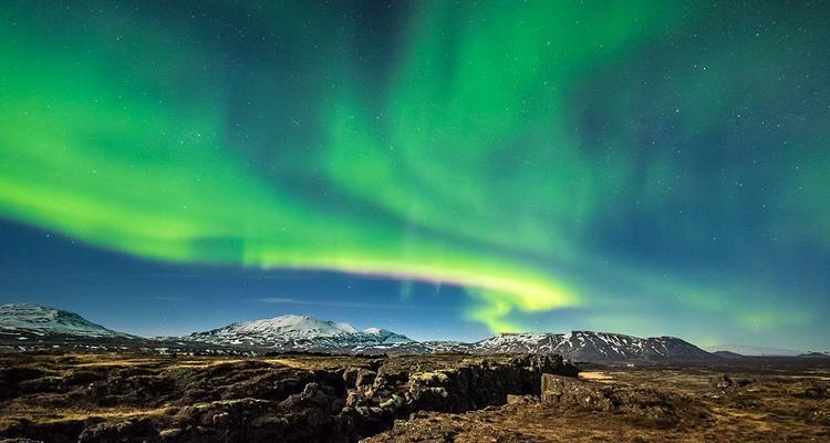 Aurores boréales au-dessus d'un paysage islandais accidenté.