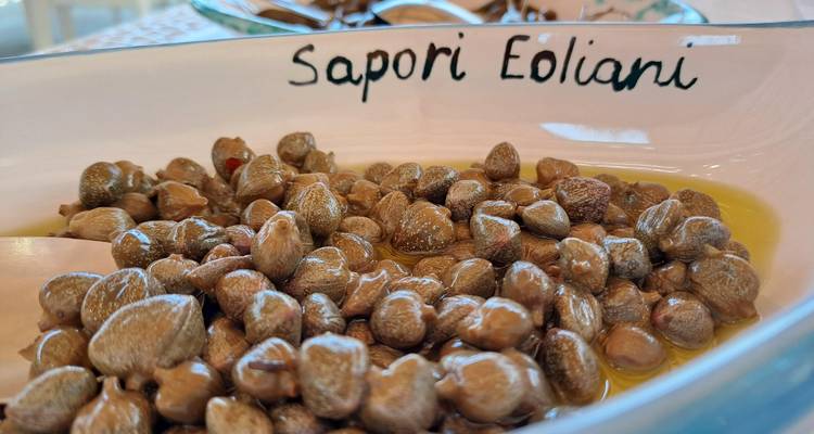 Assiette avec câpres assaisonnées étiquetée 'Sapori Eoliani'.