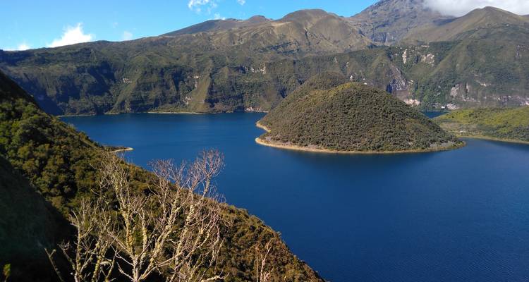Scenic view of a lake surrounded by hills and lush vegetation.