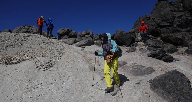Gruppe von Wanderern, die ein felsiges Gelände hinabsteigen.