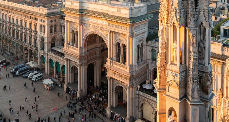 Aerial view of a grand architectural square bustling with people.