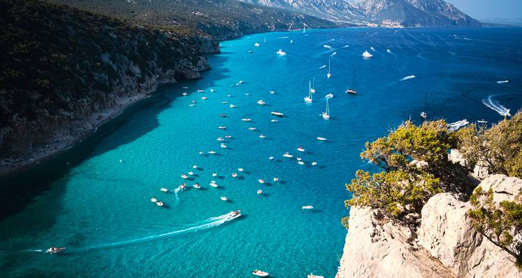 Stunning coastal view with clear blue waters and scattered boats.
