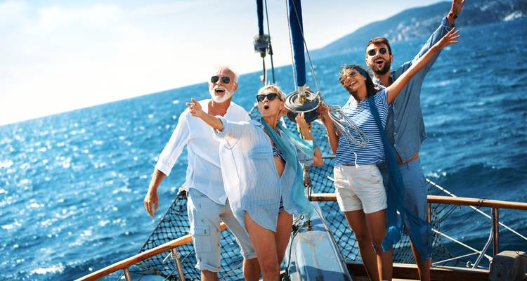 Group of friends on a boat with open sea and clear skies.