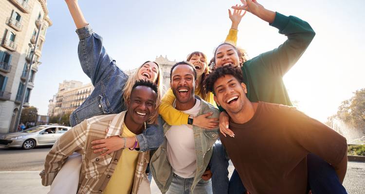 Group of happy people taking a selfie in a city street.
