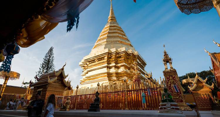 Golden stupa with intricate details in a temple complex.