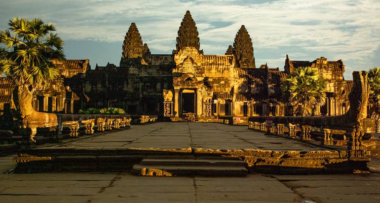 Angkor Wat tempel in warm zonsondergangslicht met dramatische schaduwen.